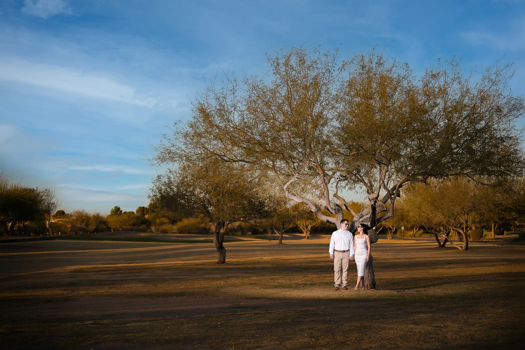 Sesion de pareja en campo abierto con cielo amplio