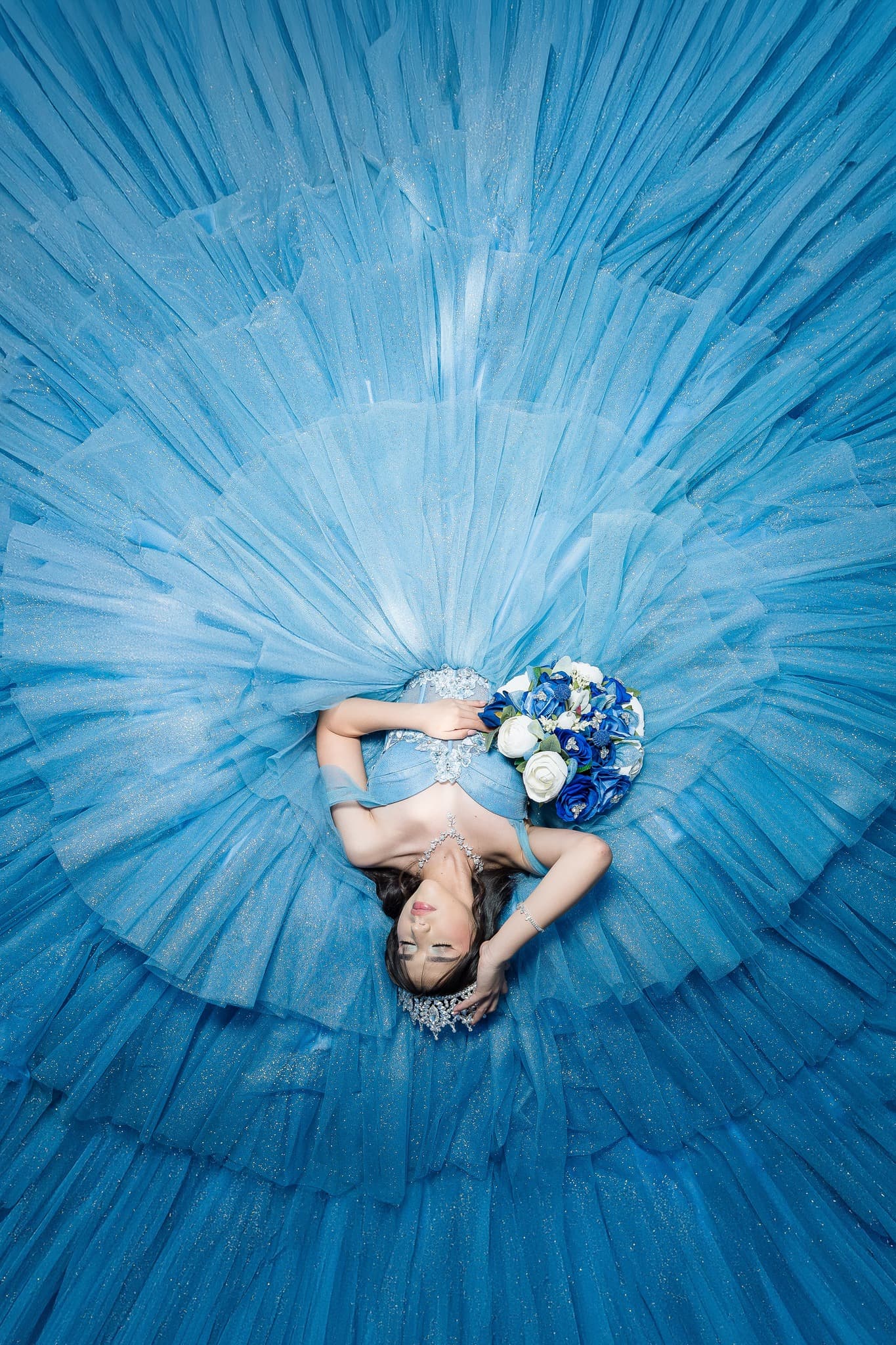 Quinceañera en vestido azul fotografiada desde arriba