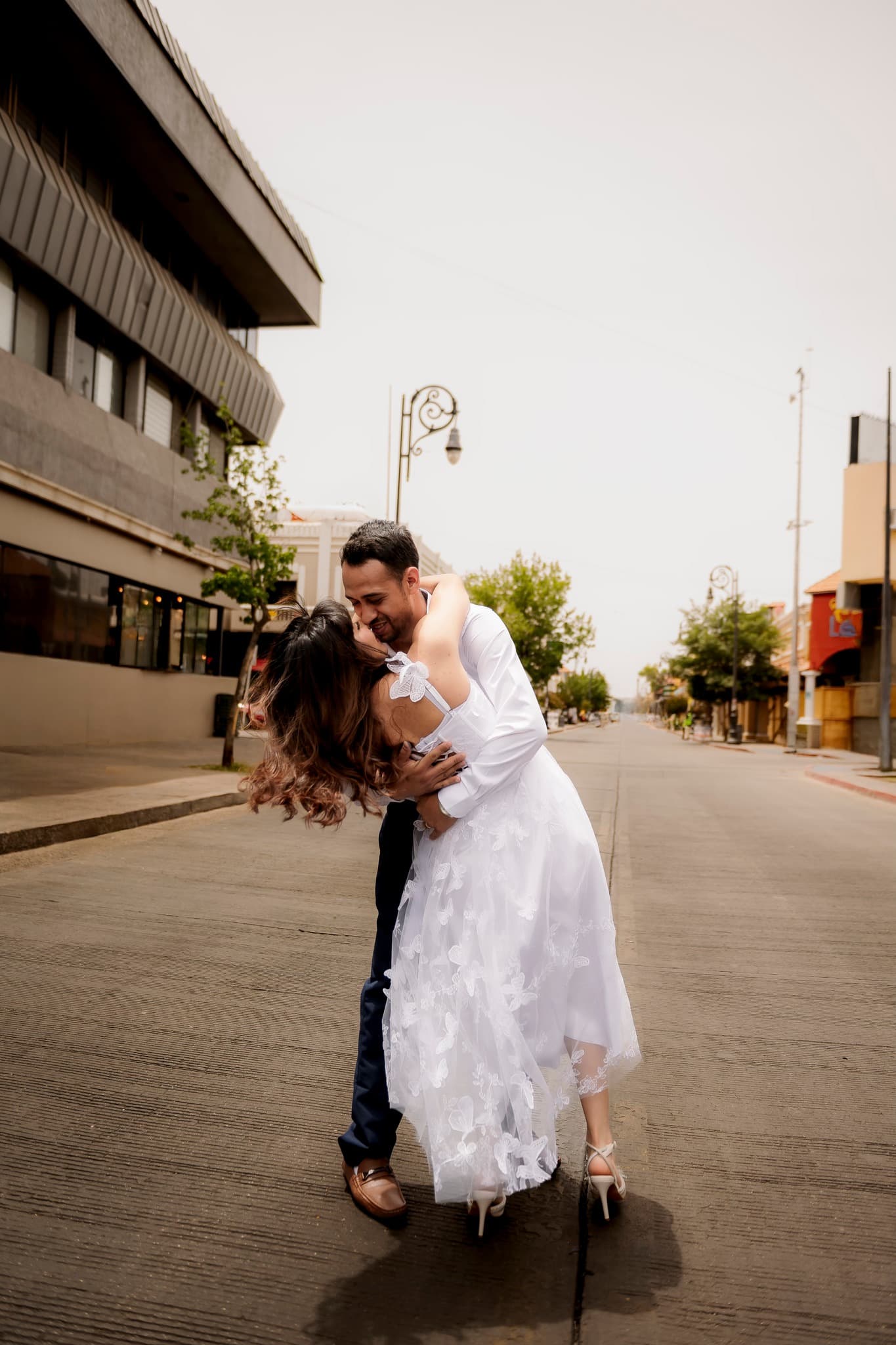 Sesion de pareja en calle urbana con vestido blanco