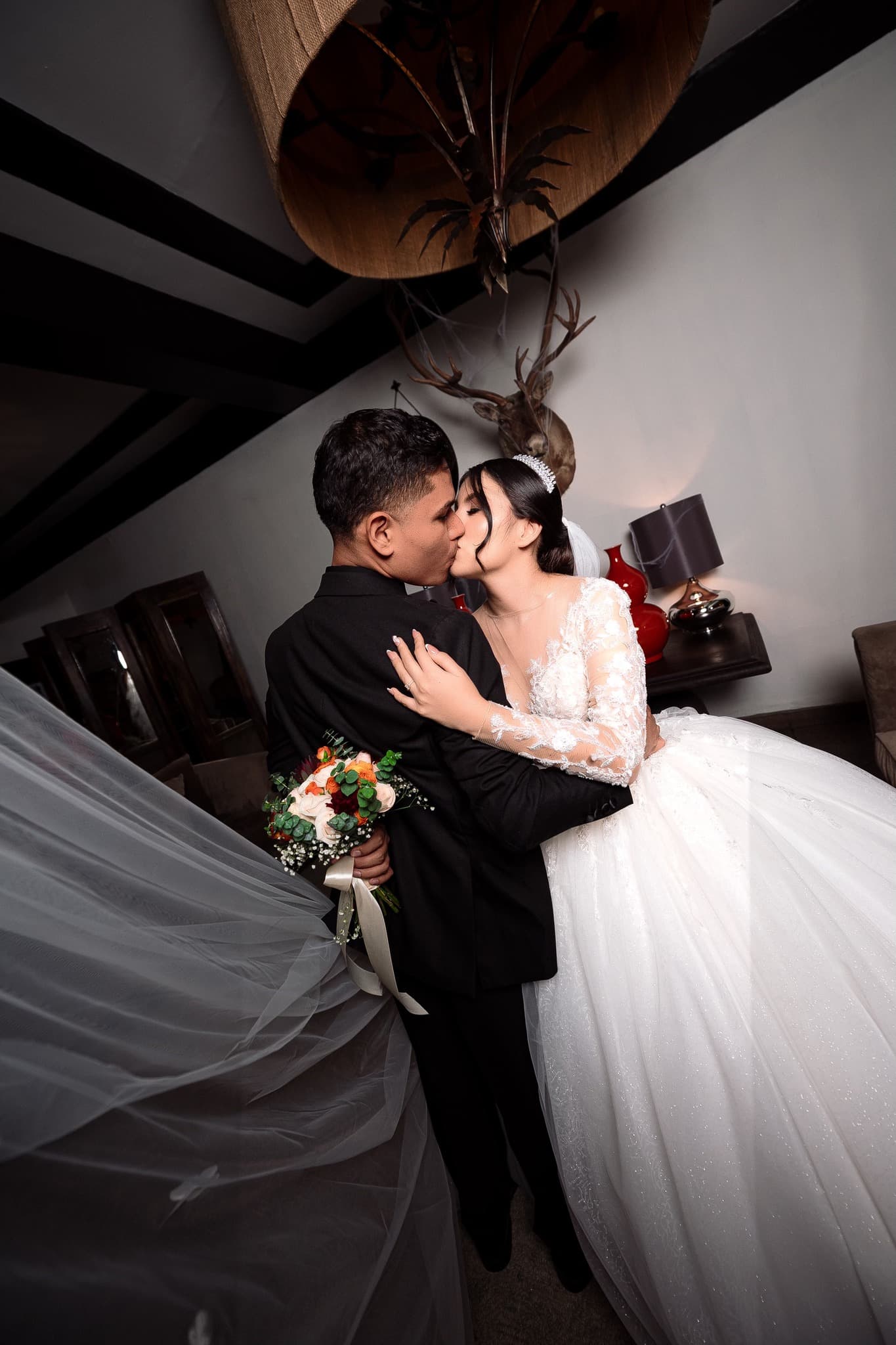Retrato de boda en interior con velo en movimiento